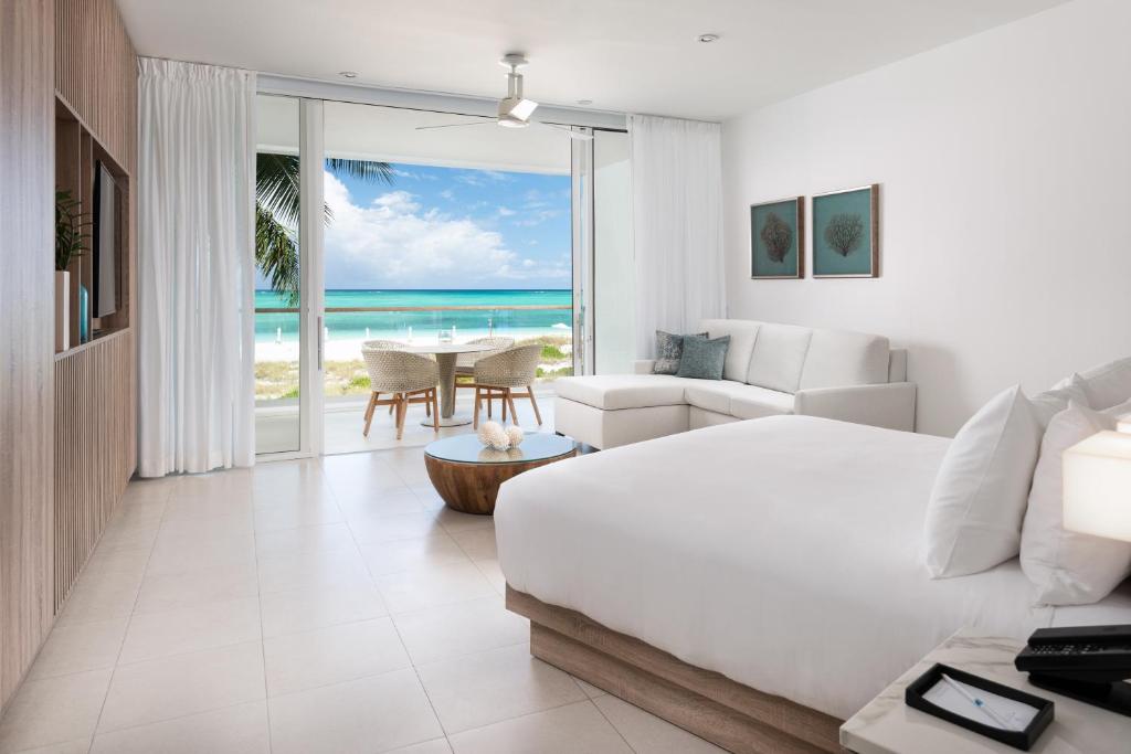 格雷斯湾Wymara Resort & Villas的一间卧室配有一张床,客厅享有海景