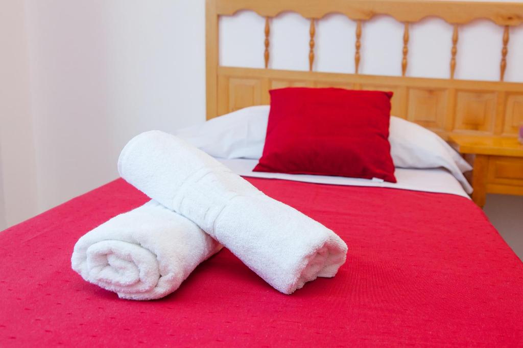 圣安东尼奥普约特公寓酒店的床上毛巾和红色毯子