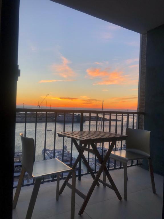 德尼亚Harbour Views Puerto Denia II的阳台的桌椅享有日落美景