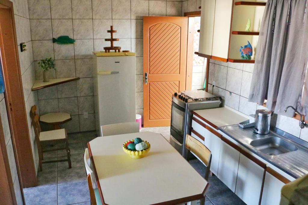 巴拉那州蓬塔尔Apartamento Beira Mar的厨房配有一张桌子,上面放着一碗水果
