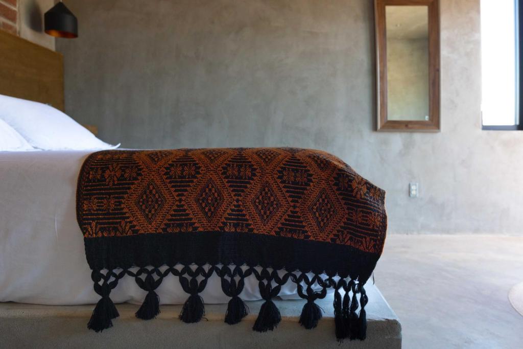 瓜达鲁佩镇Casa Michaus Valle de Guadalupe的床上铺有棕色和黑色的毯子