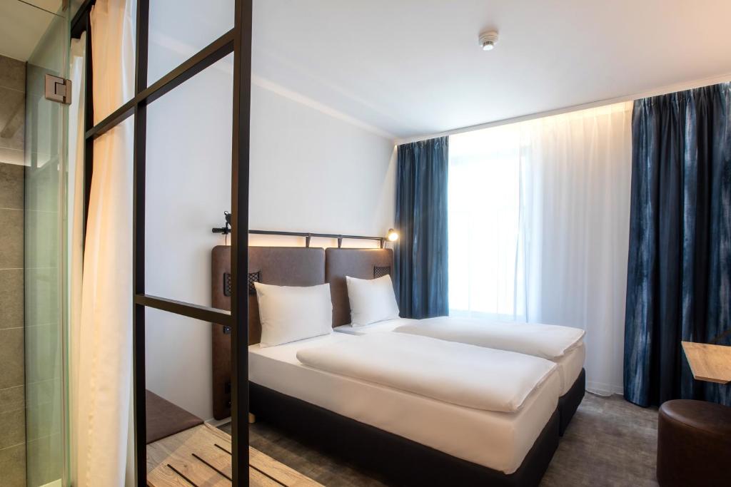 布达佩斯H2 Hotel Budapest的一间卧室设有一张床和一个窗口