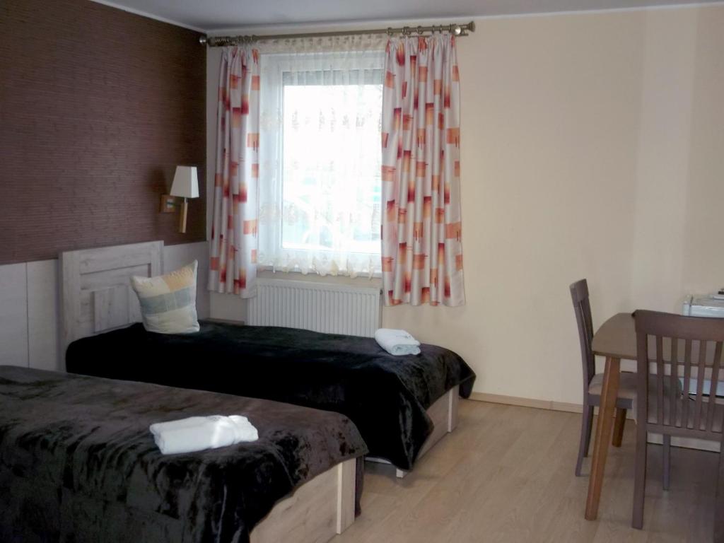 RumšiškėsKambarių nuoma - Rumšiškės SAURIDA的一间卧室设有两张床、一个窗口和一张桌子
