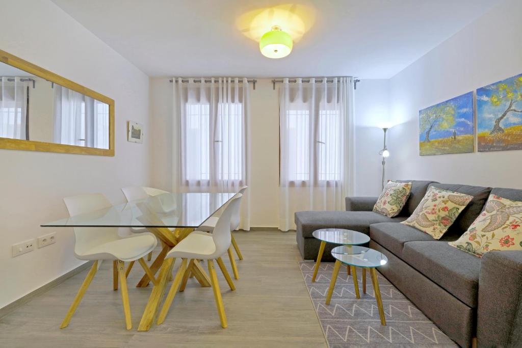 科尔多瓦Tejón y Marín, nuevo apartamento en casco antigüo的带沙发和玻璃桌的客厅