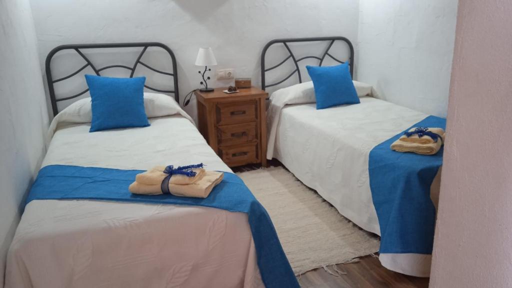 El CercadoCasa Osciris的一间卧室配有两张带蓝色枕头的床