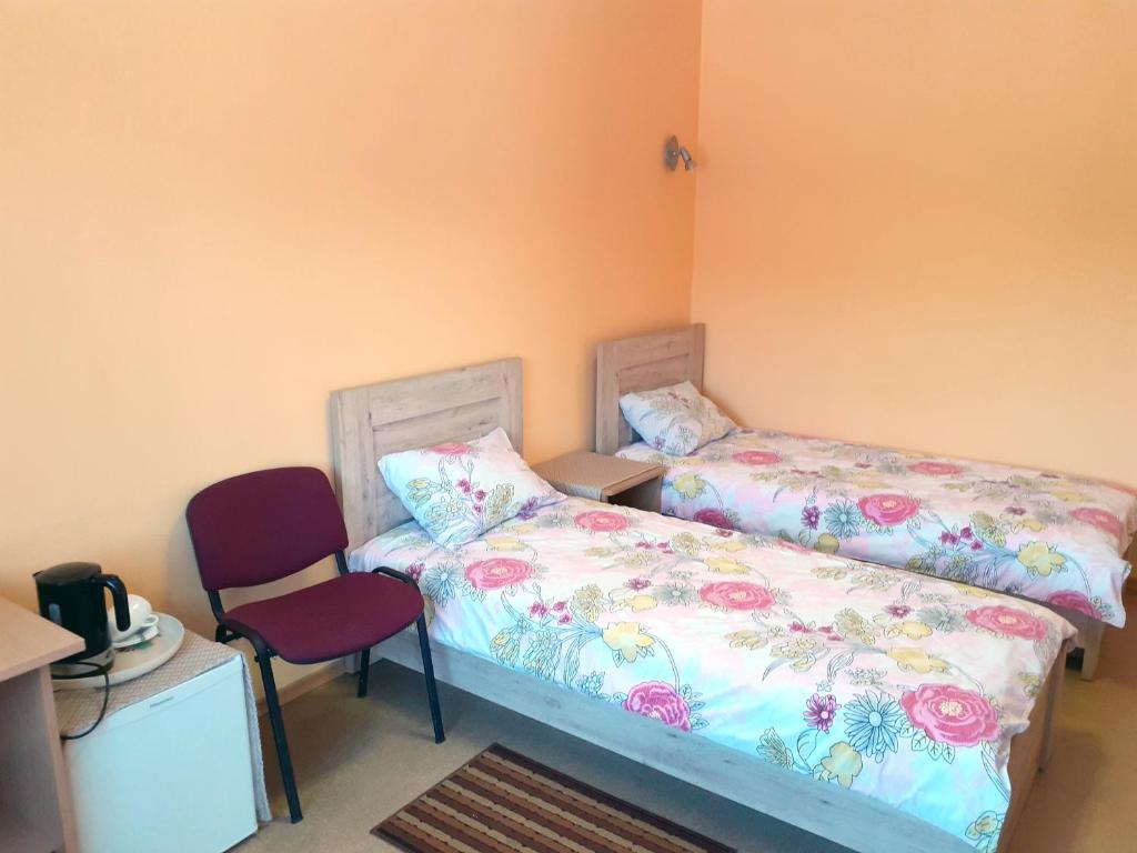 NeveronysKambarių nuoma - Neveronys SAURIDA的一间卧室配有两张床和红色椅子