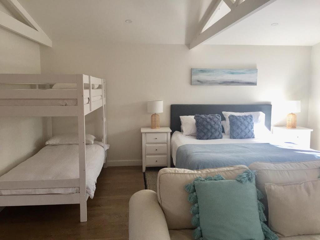 FreshwaterBijoux Beach House的一间卧室配有双层床和沙发