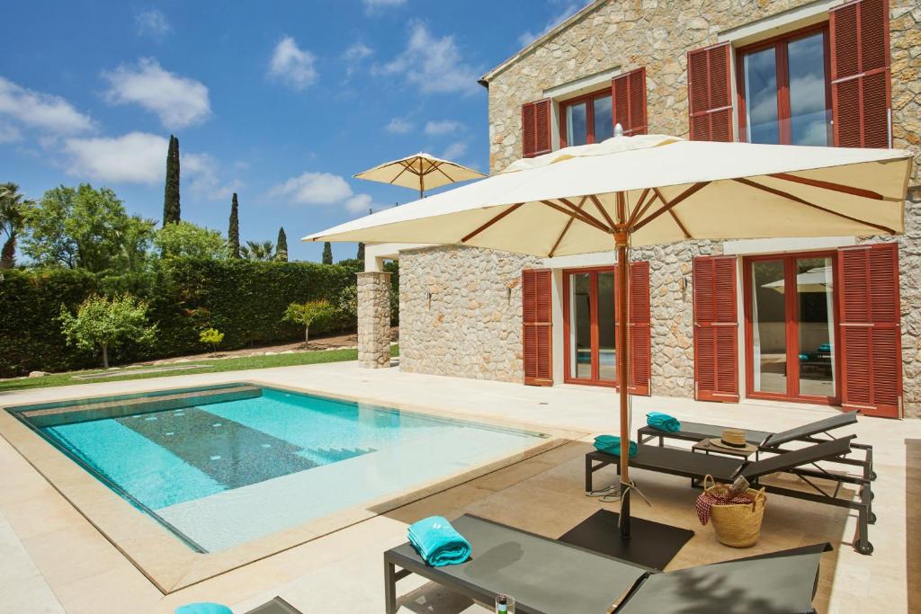 坎亚梅尔Villa Jade by Cap Vermell Estate的一座带游泳池和遮阳伞的别墅