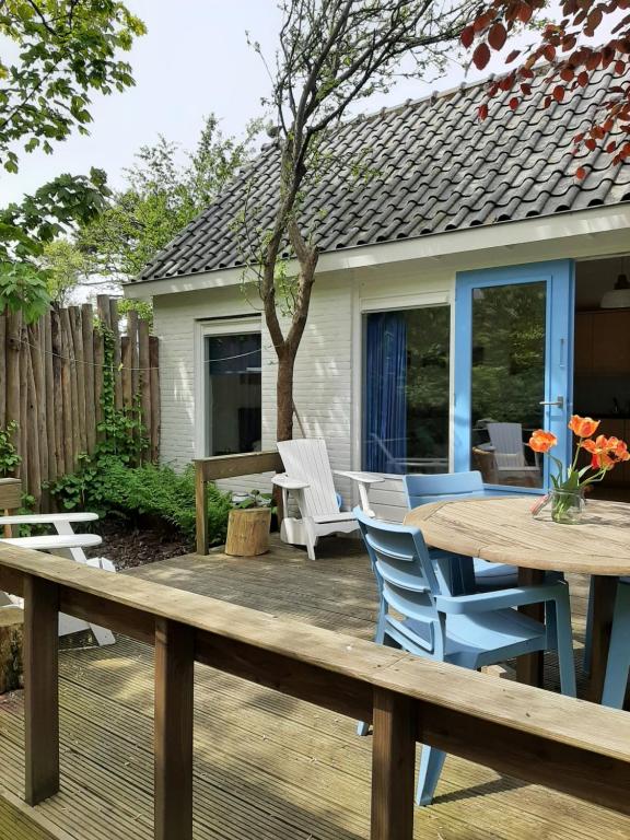 佩滕Boshuisje Petten aan Zee的木制甲板上配有桌椅