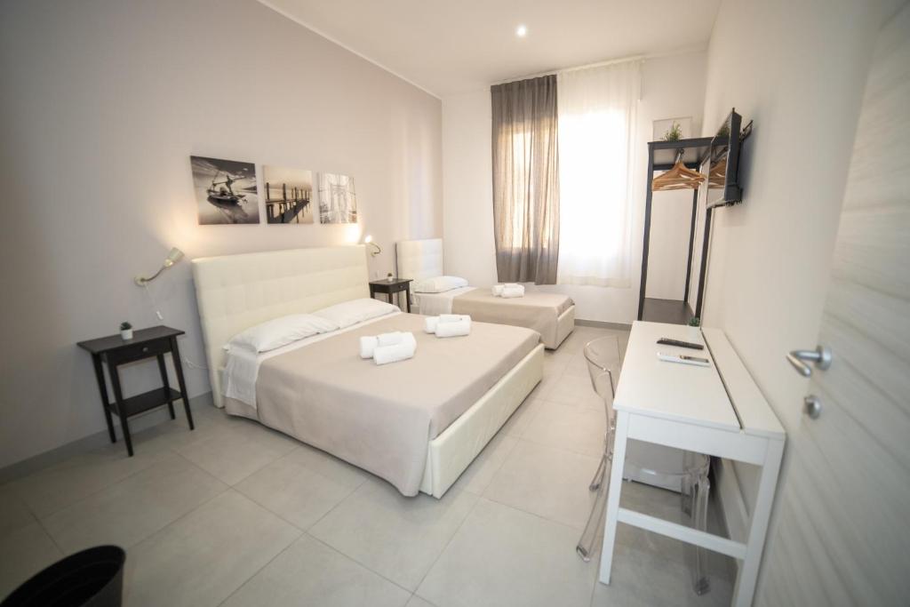 阿沃拉b&b Zio Luciano的白色的客房配有床、书桌和床。