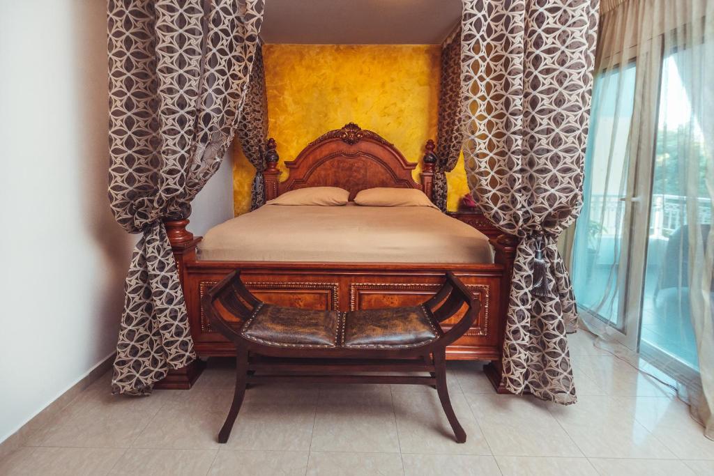 伊利索斯Villa Mika Near Ialysos Beach的一间卧室配有一张带窗帘和椅子的木床