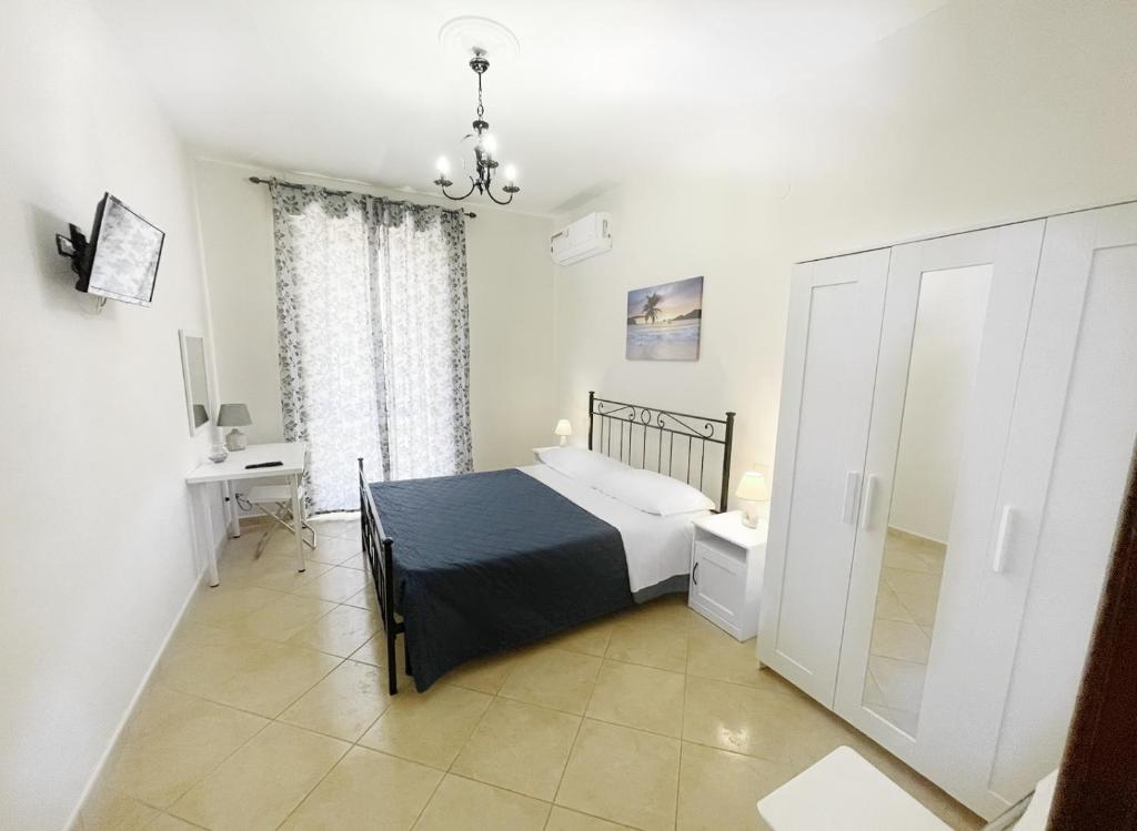 卡斯特拉玛雷帝斯达比亚Flavia Apartment的一间卧室配有一张床、一张书桌和一个窗户。