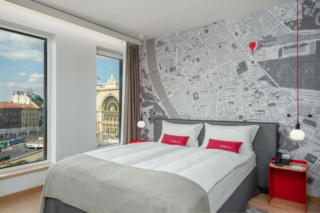 布达佩斯IntercityHotel Budapest的一间卧室配有一张带红色枕头的大床