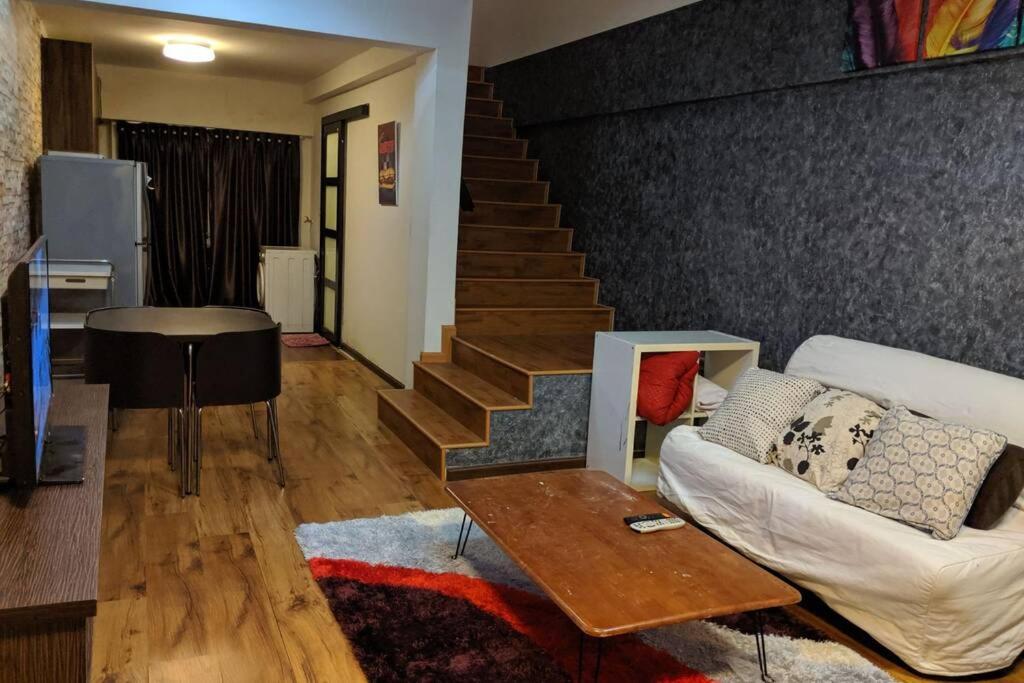 安邦Cozy designer loft near KL city center的带沙发和楼梯的客厅