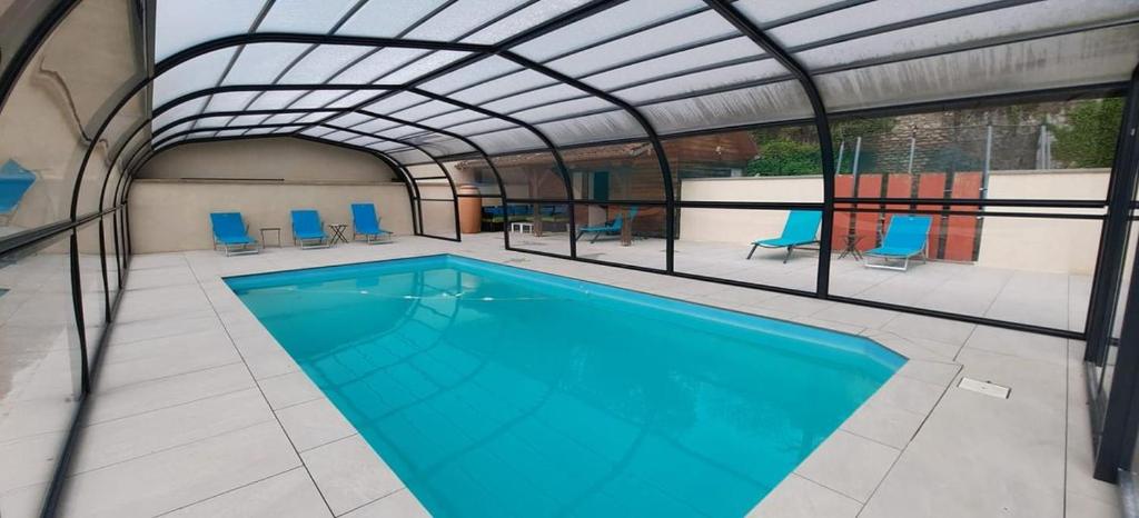 RangChambres d'hôtes Les Charmettes的一座带金属屋顶的室内游泳池