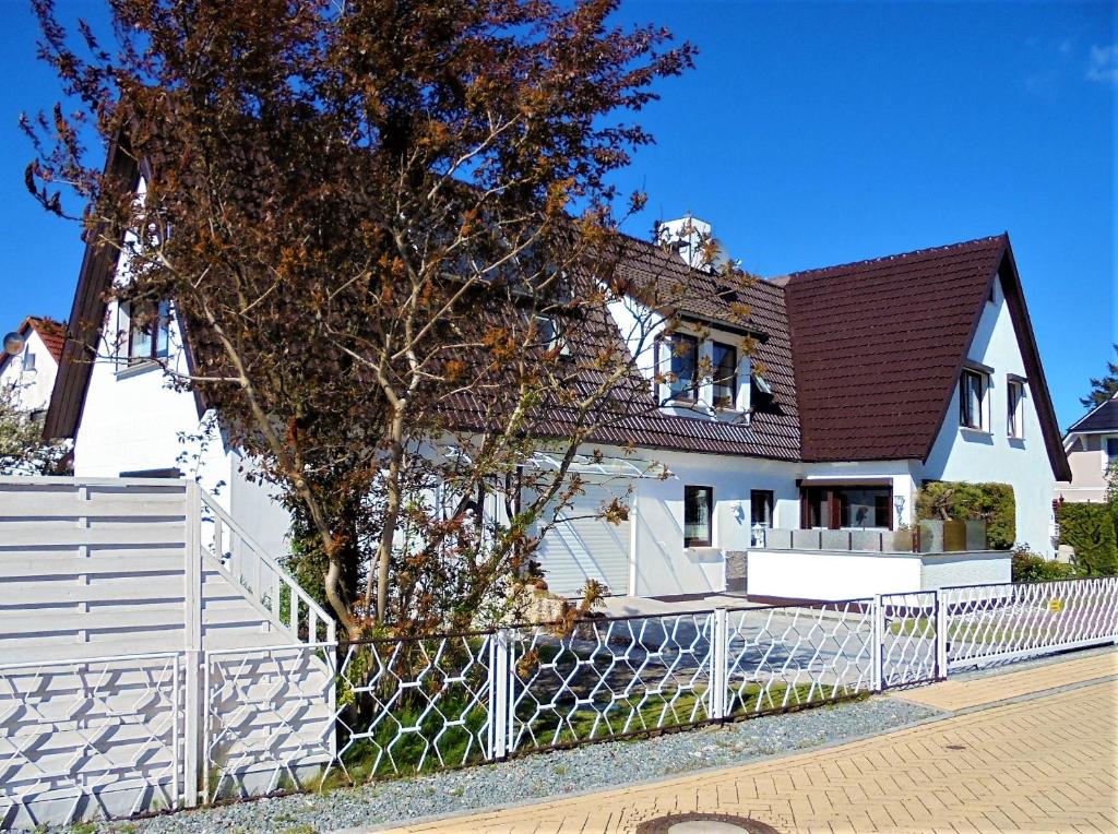 青斯特Ferienwohnungen/Ferienzimmer Seidel的前面有栅栏的白色房子