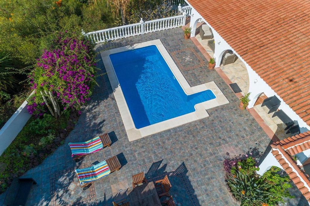 绍萨尔Villa Marina的享有带椅子的游泳池和房屋的顶部景致