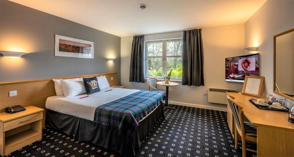 戴斯Pinehurst Lodge Hotel - Aberdeen的酒店客房,配有床和电视