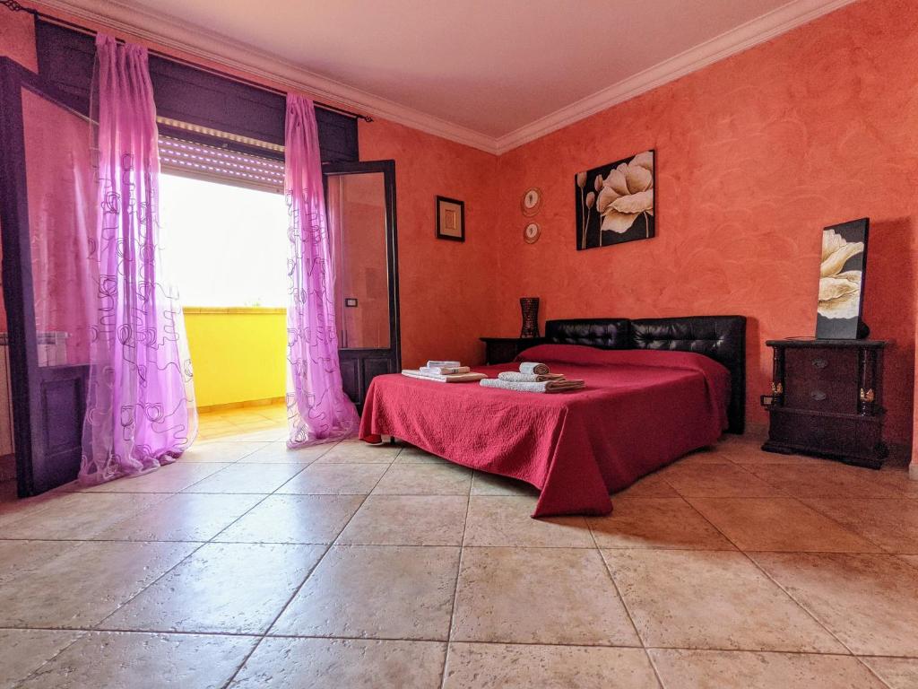 特拉帕尼B&B A Casa di Angela的一间卧室配有红色的床和红色毯子
