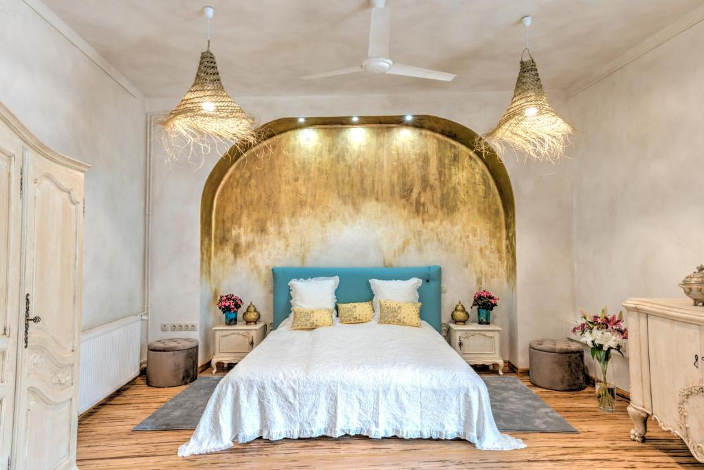 圣安德烈Lotus apartment的一间卧室配有一张大床和金色床头板