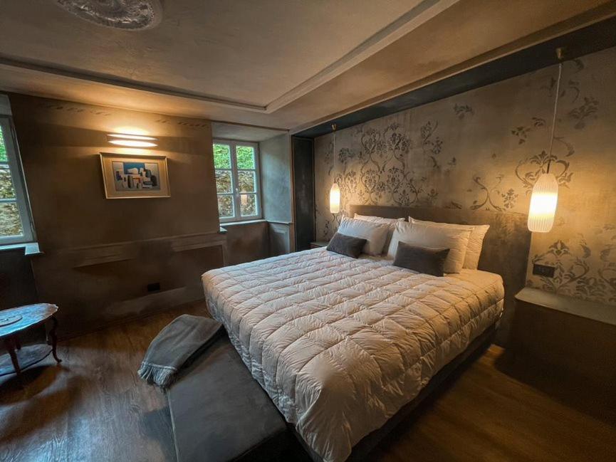 坎诺比奥DIMORA SCURONE的一间卧室设有一张大床和两个窗户。