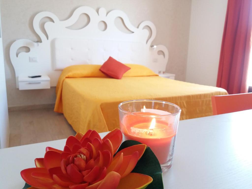 塔维亚诺Tesori del Salento的一张桌子上的蜡烛和一朵花,床上