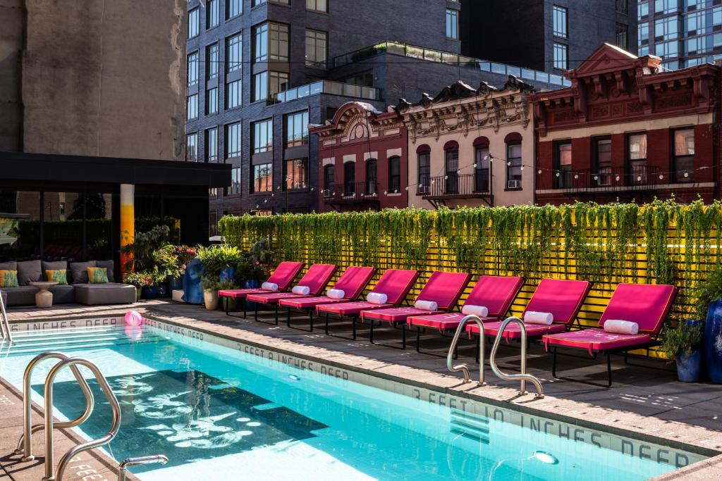 纽约瑟斯提莱斯酒店的游泳池旁的一排粉红色椅子