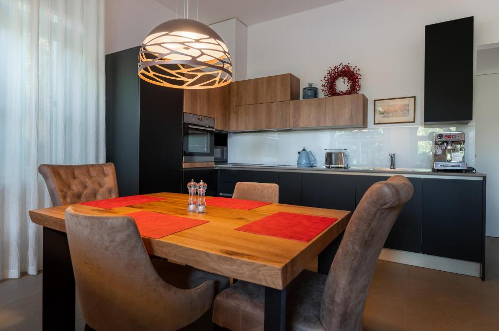 波尔托罗Luxury Apartments Portoroz的厨房配有带椅子的木桌