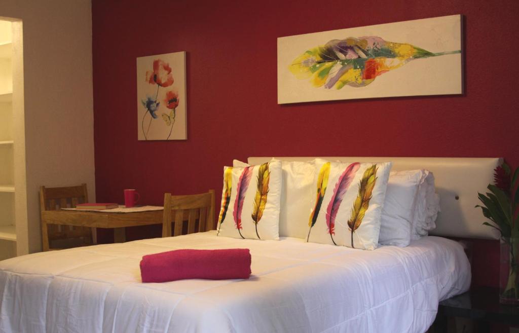 危地马拉Super Precio的卧室内的一张带白色床单和枕头的床
