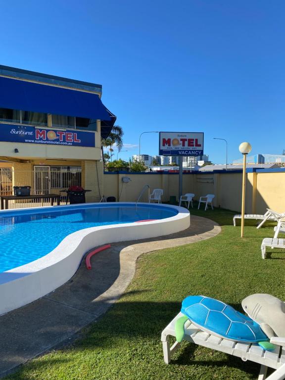 黄金海岸旭日汽车旅馆的一座带两把椅子的建筑屋顶上的游泳池
