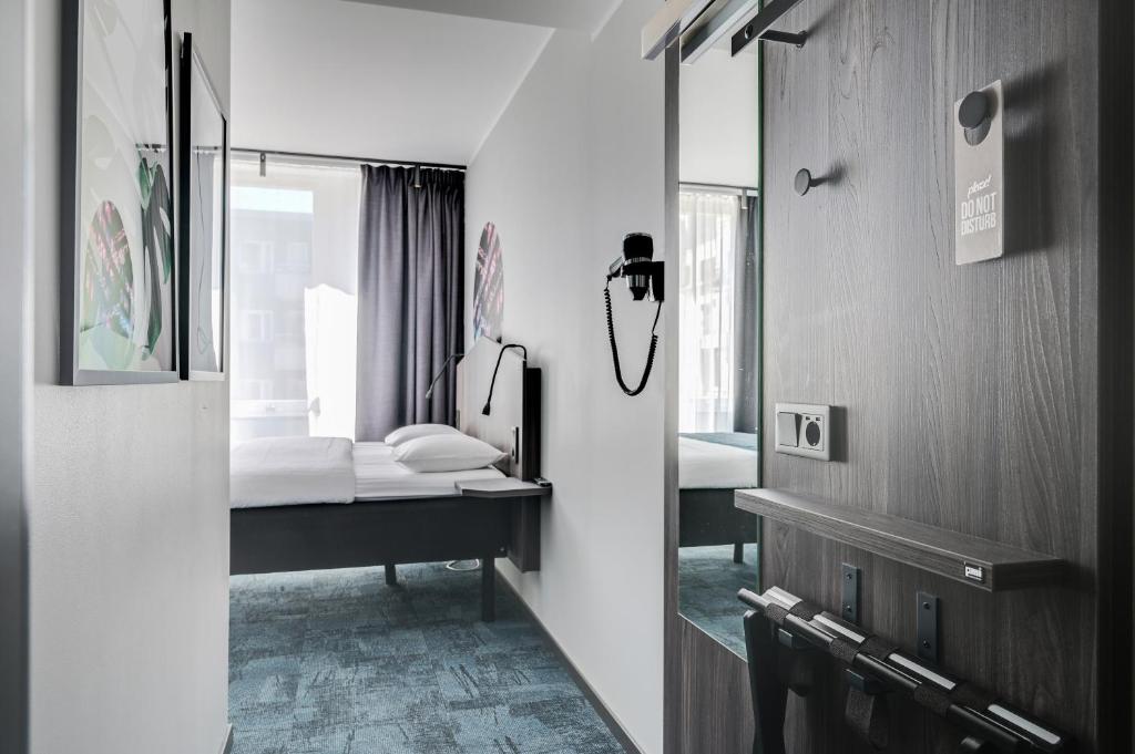 斯德哥尔摩Hotel Fridhem的一间小卧室,配有一张床和镜子