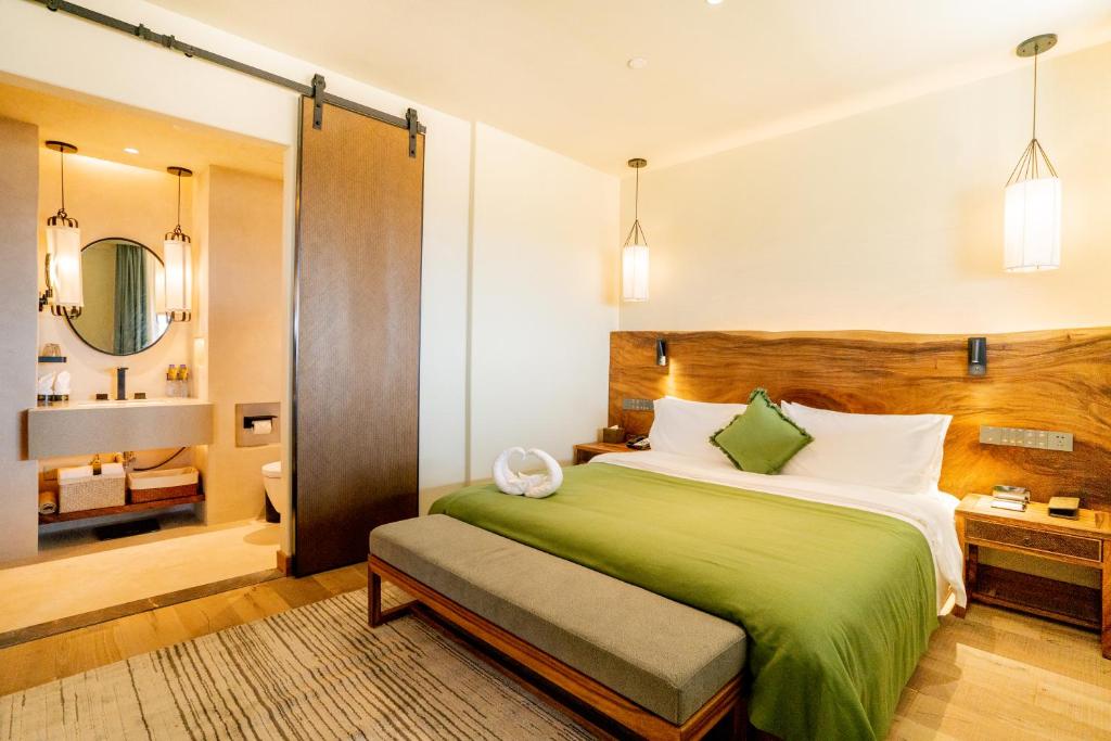 南京南京溧水中山湖金陵文璟酒店的一间带绿色床的卧室和一间浴室