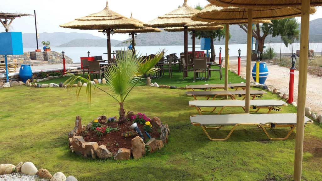 伊罗达伊罗达日出公寓酒店的海滩上一组桌椅和遮阳伞