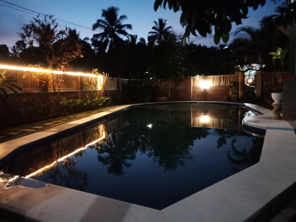 BatukliangBello Bungalow的夜间后院的游泳池