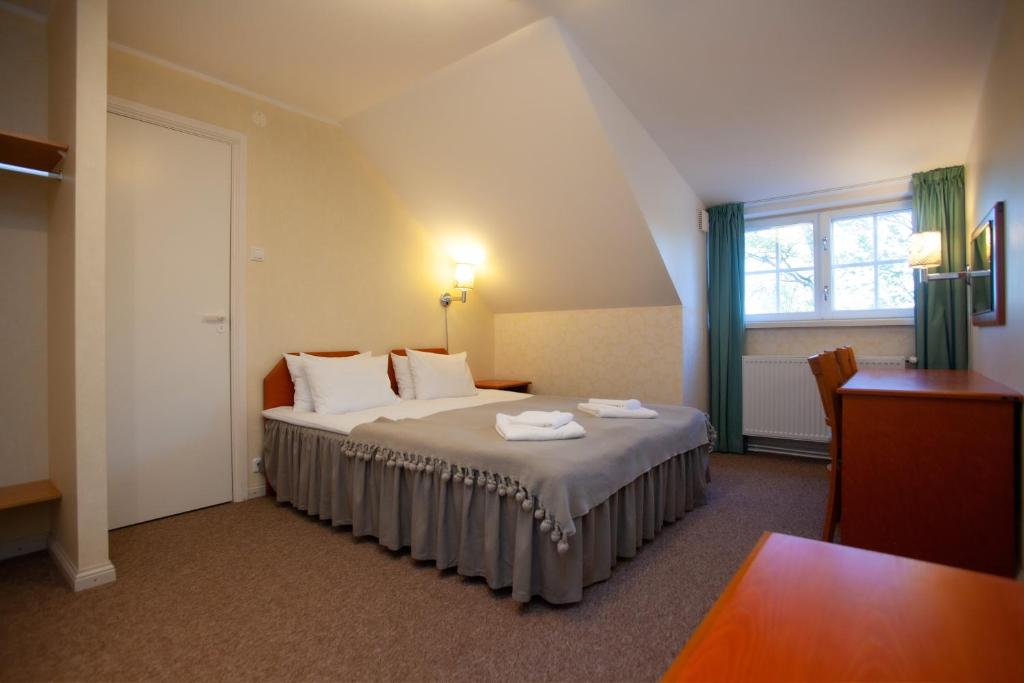KihelkonnaLoona Manor Guesthouse的一间卧室配有一张床,上面有两条毛巾
