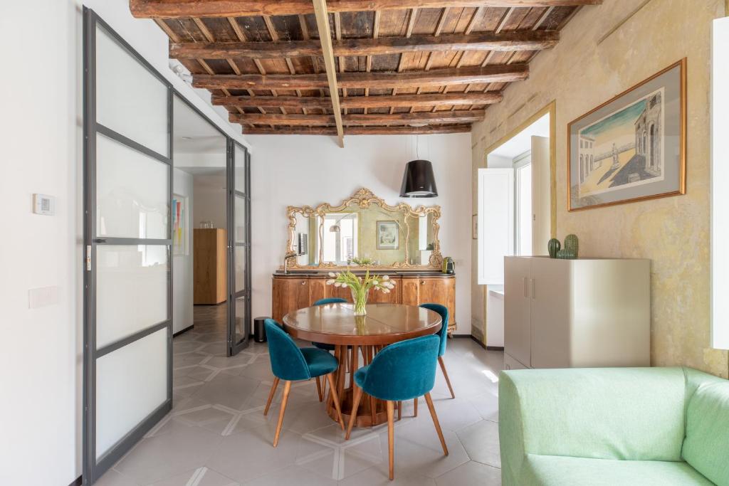 罗马iFlat Vatican High-End Apartment的一间带木桌和蓝色椅子的用餐室