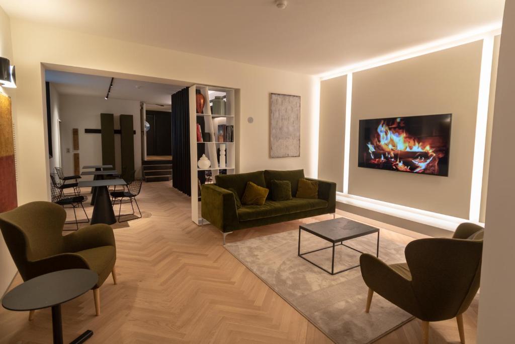 阿西西Hotel La Terrazza RESTAURANT & SPA的客厅配有绿色沙发和桌子