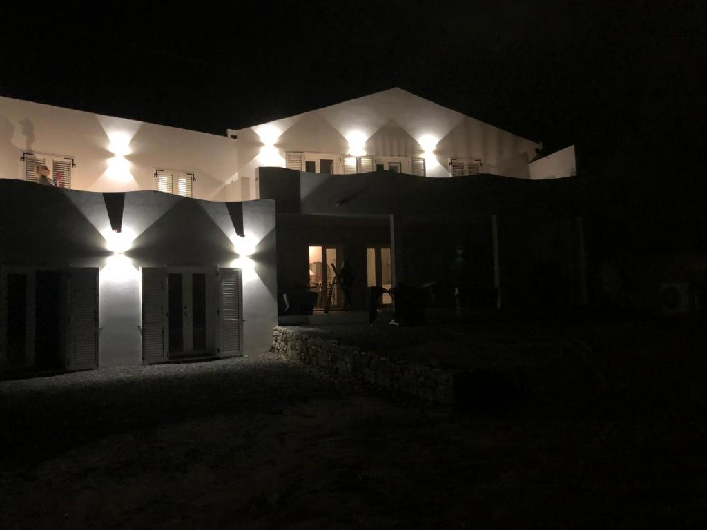 卡洛福泰Luxury& Charme fronte mare Sardinia House7的夜晚有灯的白色房子