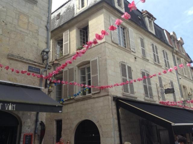 佩里格appartement coeur historique的前面有粉红色流媒体的建筑