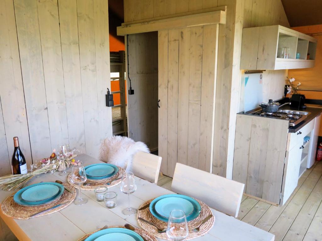 蒂尔堡Luxe safaritenten Petit013 - nieuw的厨房里一张带蓝色盘子的桌子