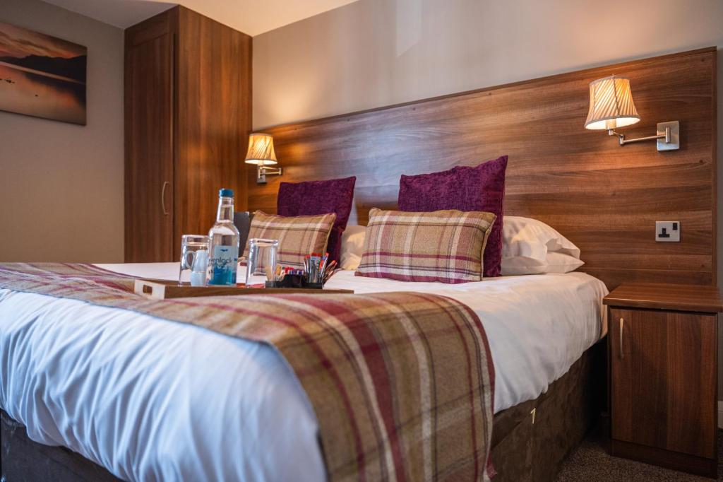 彭里斯方德瑞34酒店的一间卧室配有一张大床和木制床头板