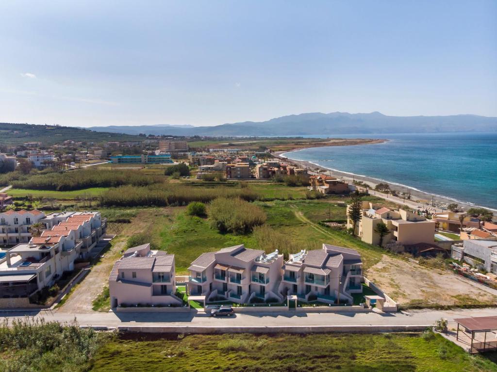 马莱迈Aegean Breeze Luxury Apartments的享有海滩的空中景致,设有房屋和海洋