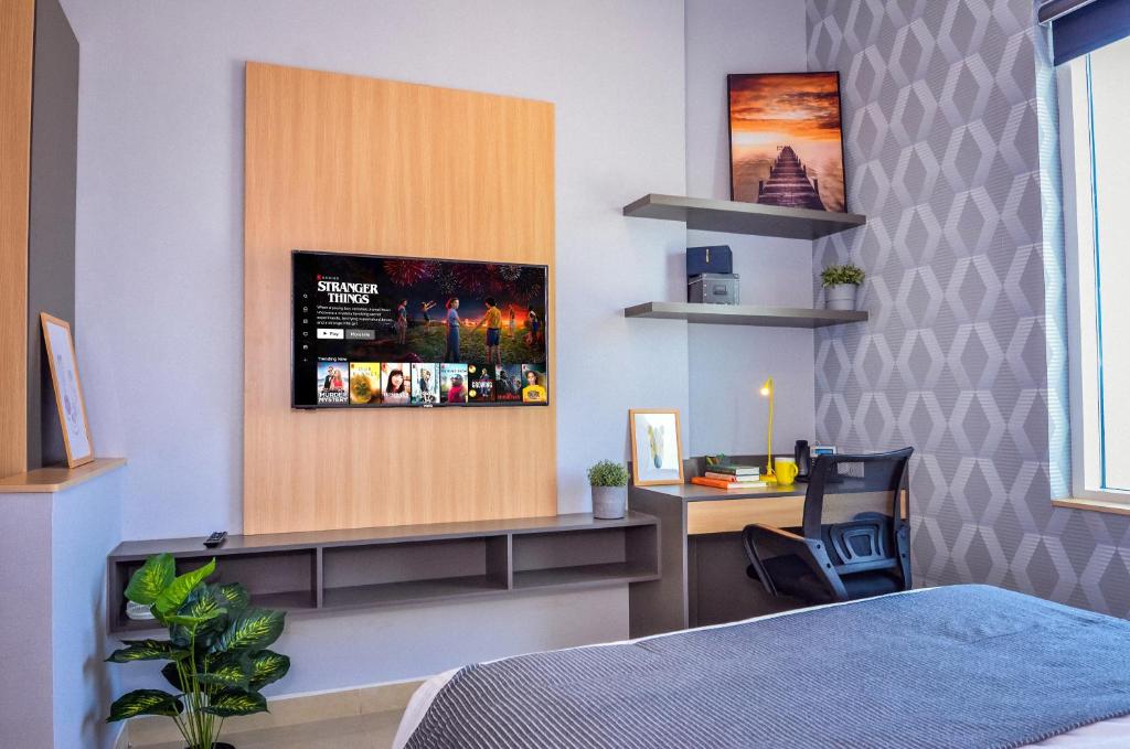 迪拜KSK Homes Hotel Dubai Academic City的一间卧室配有一张床和一张带显示器的书桌