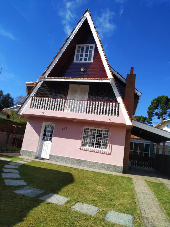坎波斯杜若尔当Casa Campos do Jordão的红色屋顶的粉红色房子