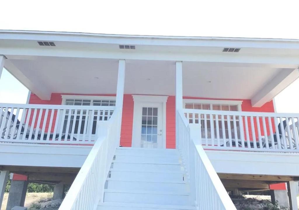 Behring PointMangrove Cay Sea View Villas的白色的红色房子,有白色的楼梯