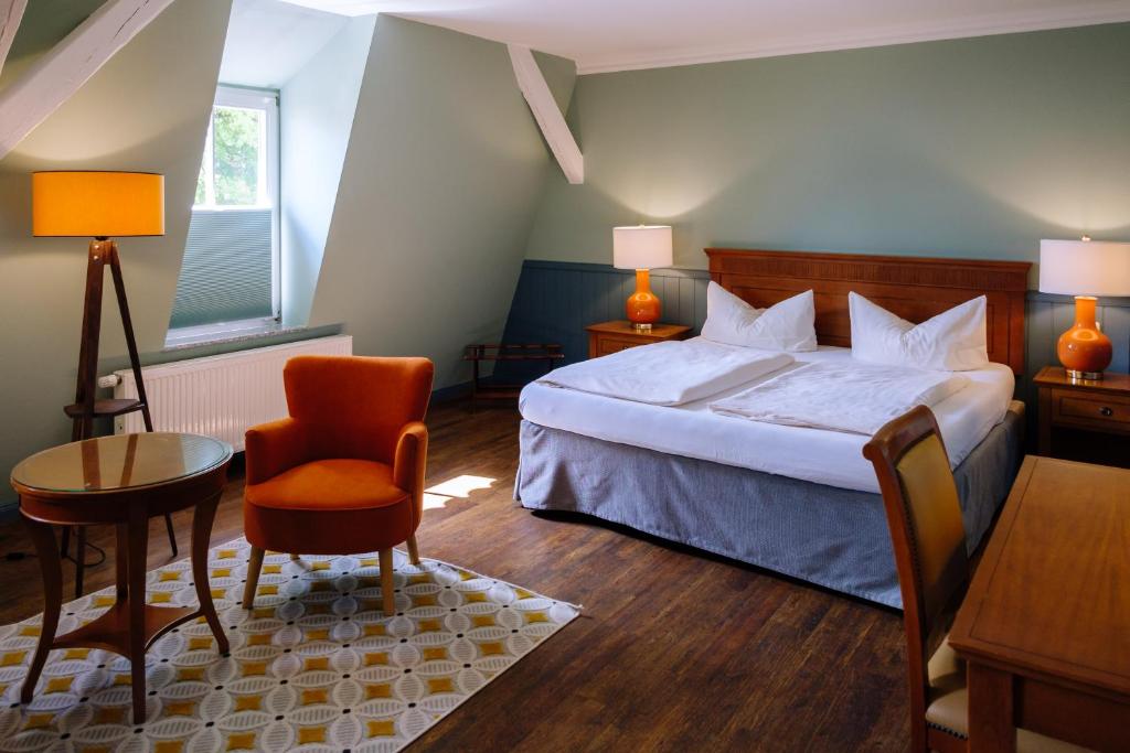 唐格明德SCHULZENS Brauerei & Hotel的卧室配有1张床、1张桌子和1把椅子