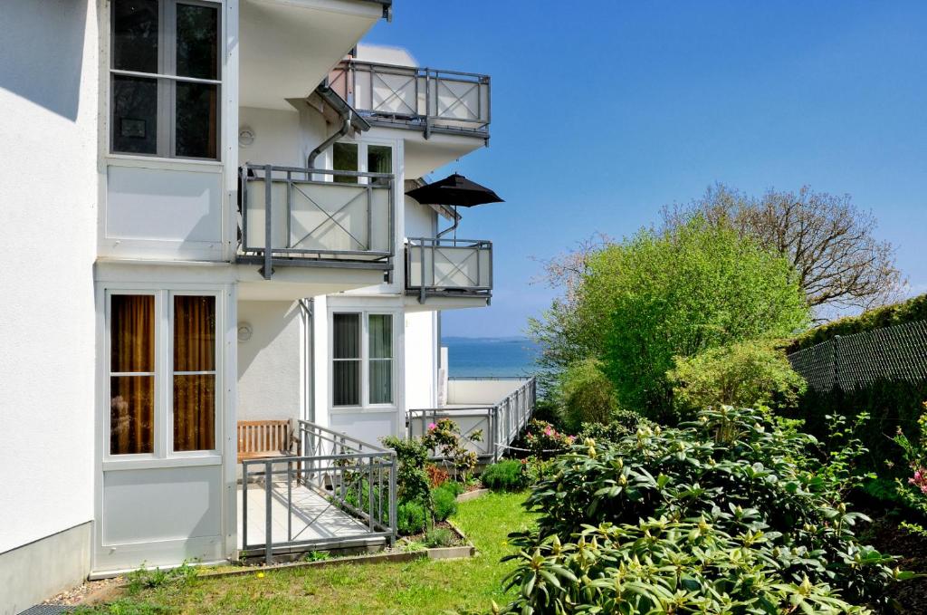 劳特尔巴赫Ferienwohnung Hafenliebe, Villa Vilmblick mit Meerblick的带阳台的白色房屋,背靠大海