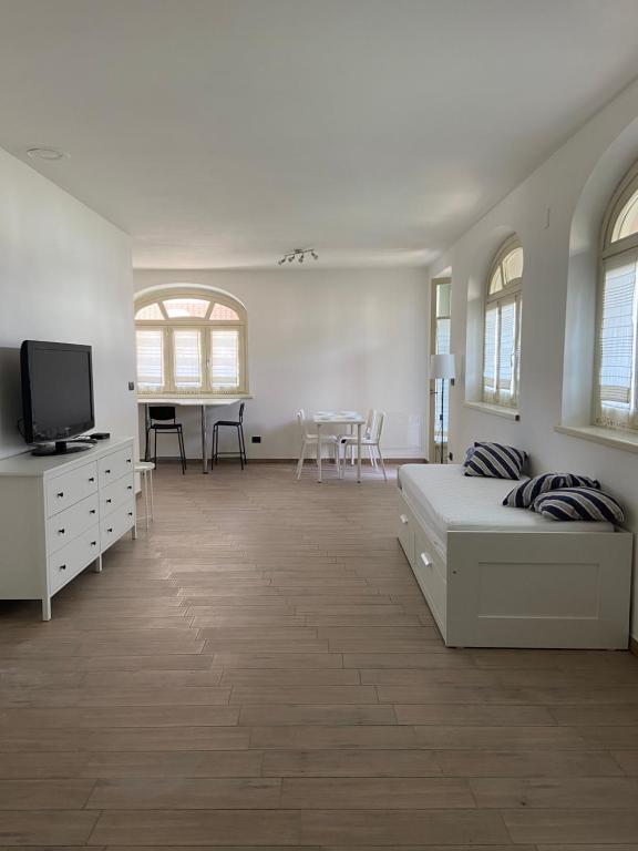 福萨诺Coronata 22的一间白色的大房间,配有床和电视