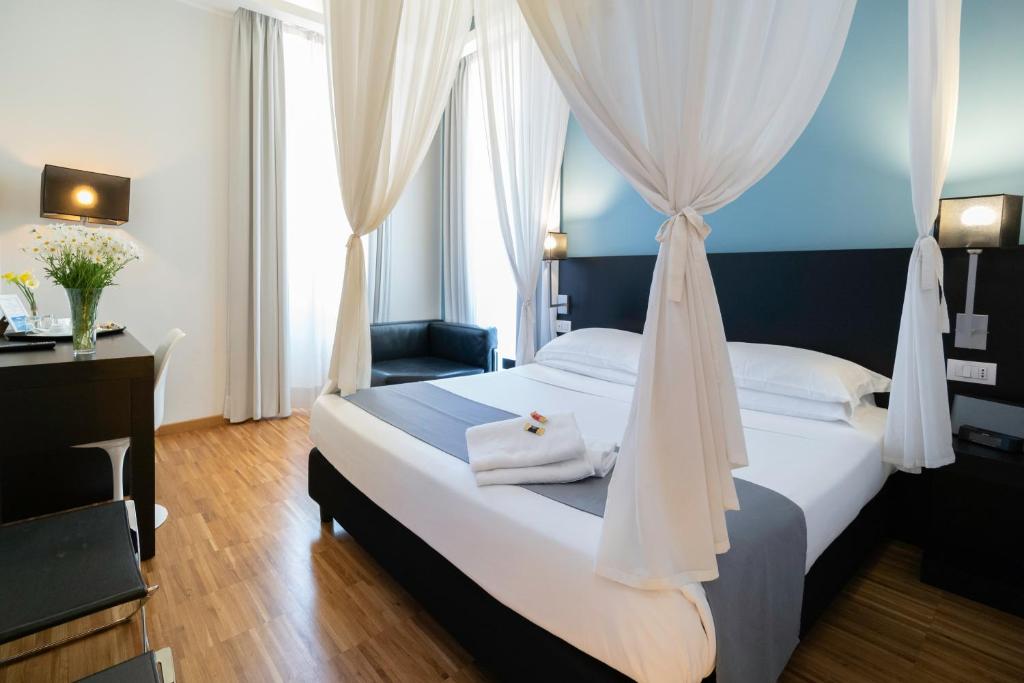 罗马菲利伯托家庭城镇酒店的一间卧室配有一张带天蓬的白色床