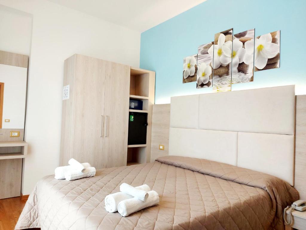 里米尼莫妮卡酒店的卧室配有2条白色毛巾。